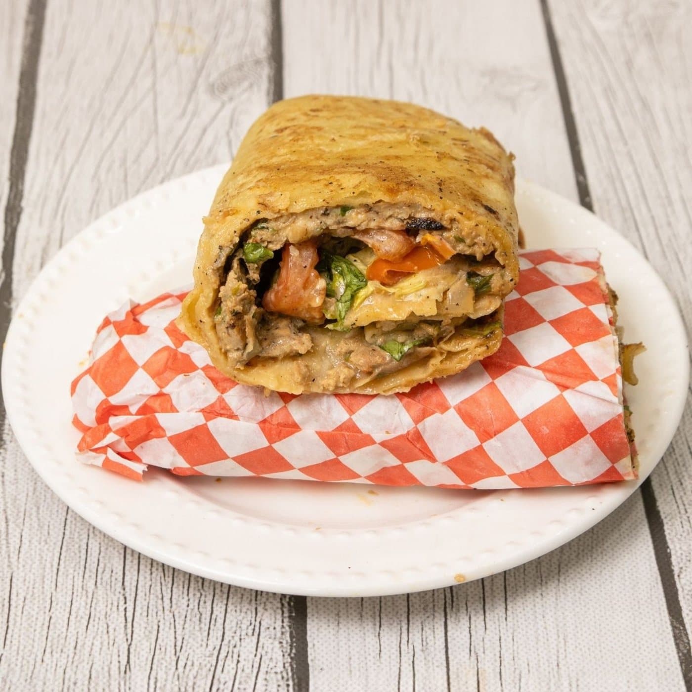 A msemen wrap filled with charcoal-grilled beef, cut to show the layers