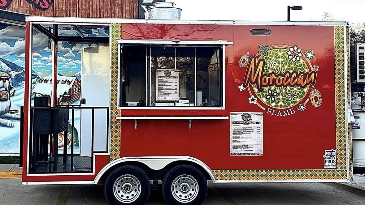 The Moroccan Flame food truck, wrapped in red, gold and green zellige patterns, on Greenville Ave in Dallas